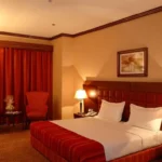 اتاق اجرایی هتل Grand Central Hotel با تخت دبل و پرده‌های قهوه‌ای