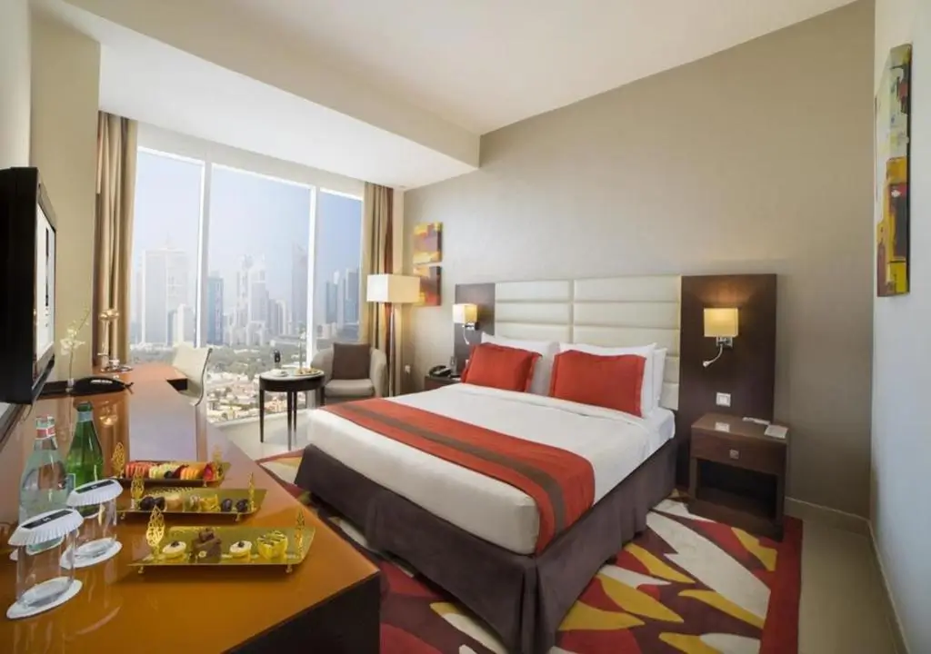 نمای کلی از اتاق Executive Room با تخت کینگ و چشم‌انداز شهر.